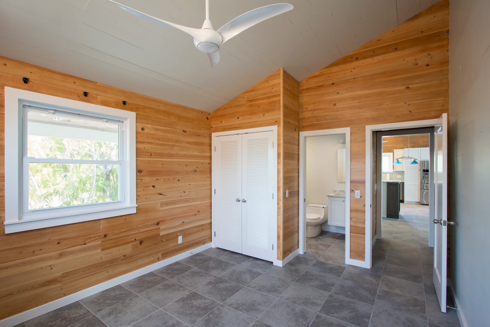 Rustic-modern bathroom renovation featuring custom wood paneling and stone tile floors in Key West