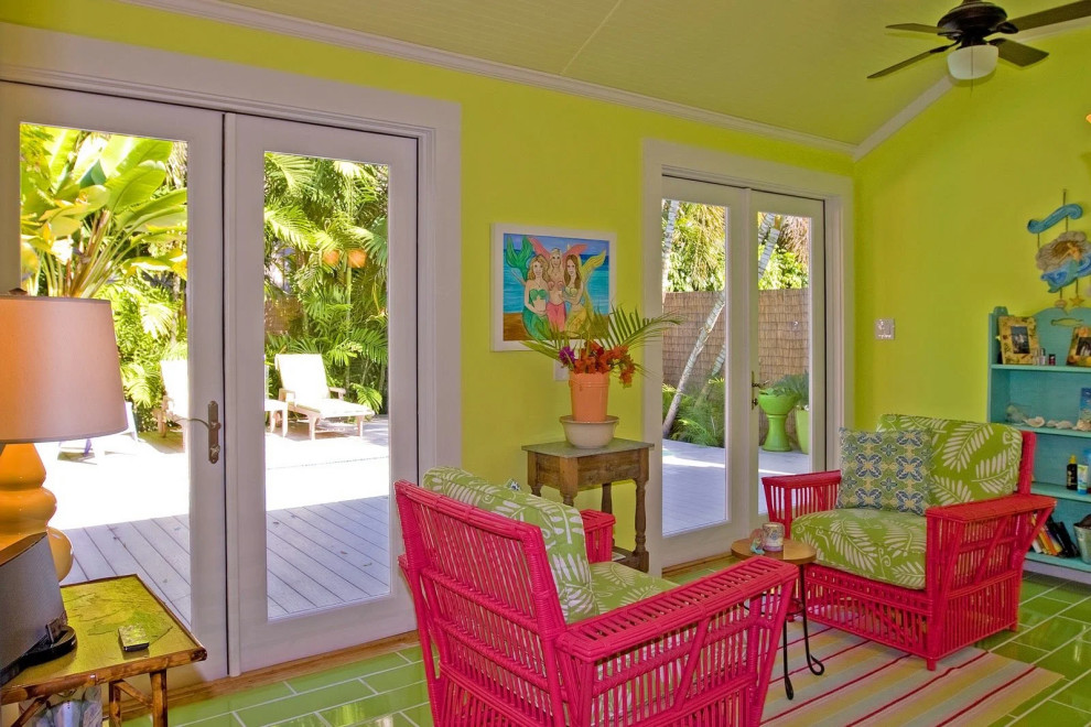 Colorful living room with yellow walls and red wicker furniture in Key West renovation