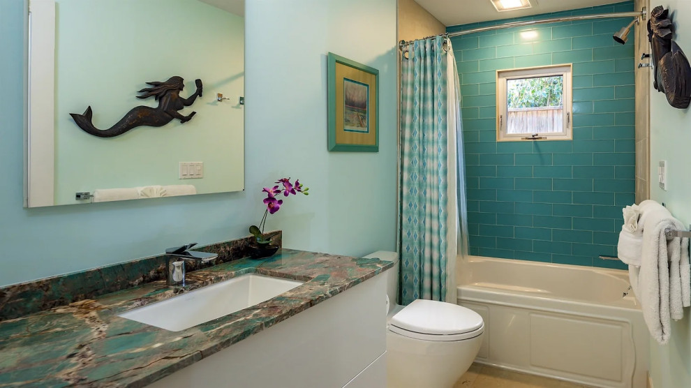 Modern bathroom with teal walls, marble vanity and decorative elements in Key West renovation