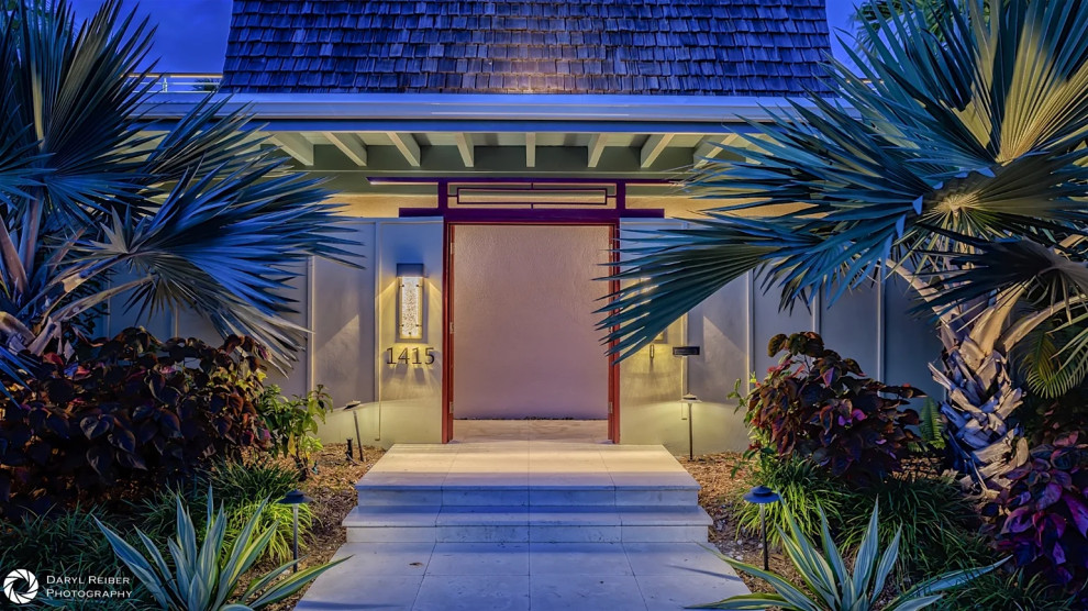 Asian-inspired entrance with red accents and lantern fixture in Key West home renovation