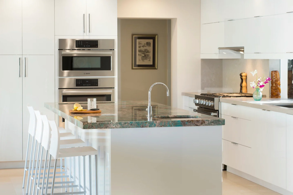 Contemporary kitchen with white cabinets and stainless steel appliances in Key West renovation