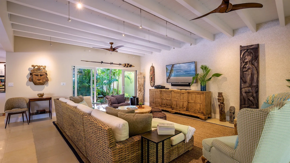 Elegant living room with exposed beams and wicker furniture in Key West renovation