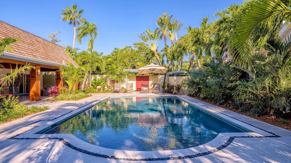 Luxury outdoor pool with tropical landscaping and covered porch in Key West renovation