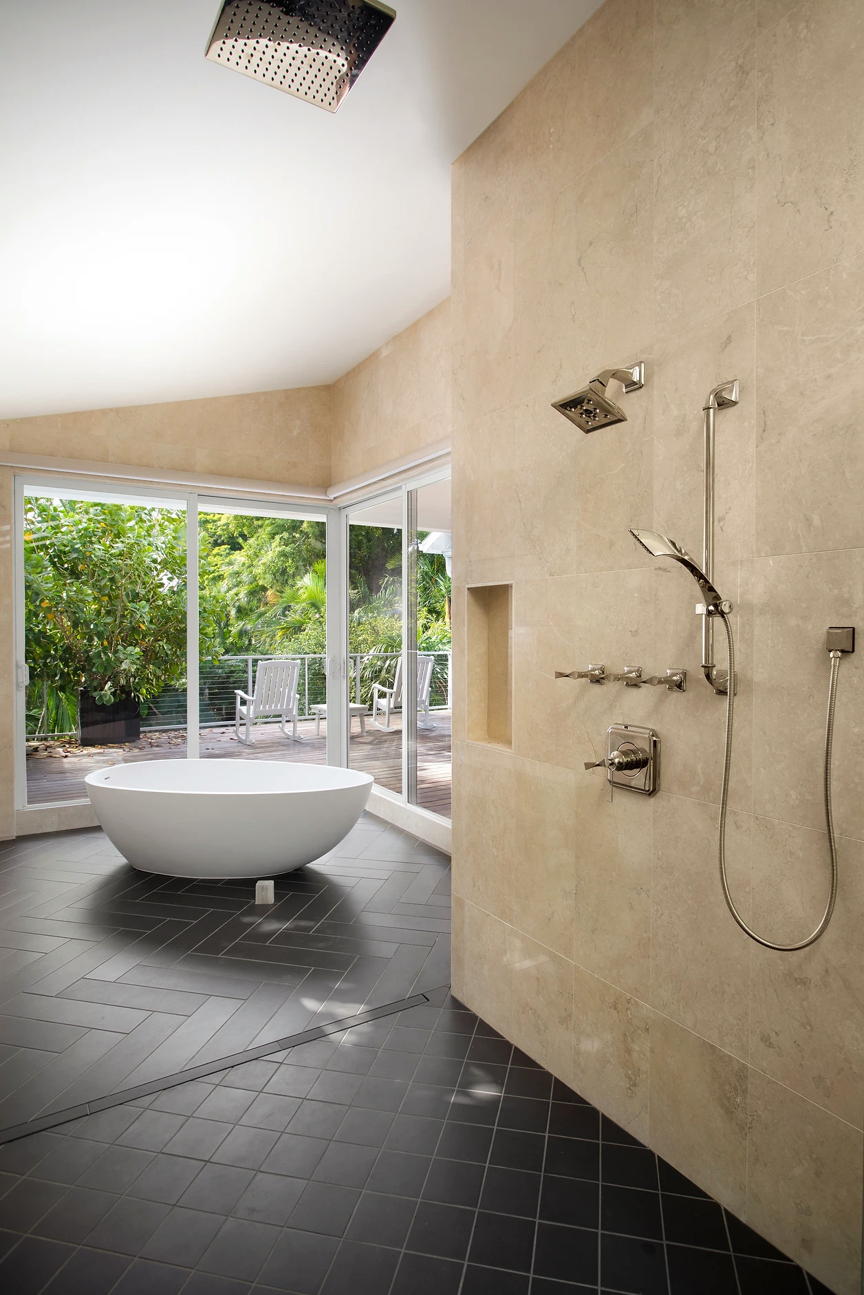 Modern bathroom renovation with large round tub and patio access in Key West retreat