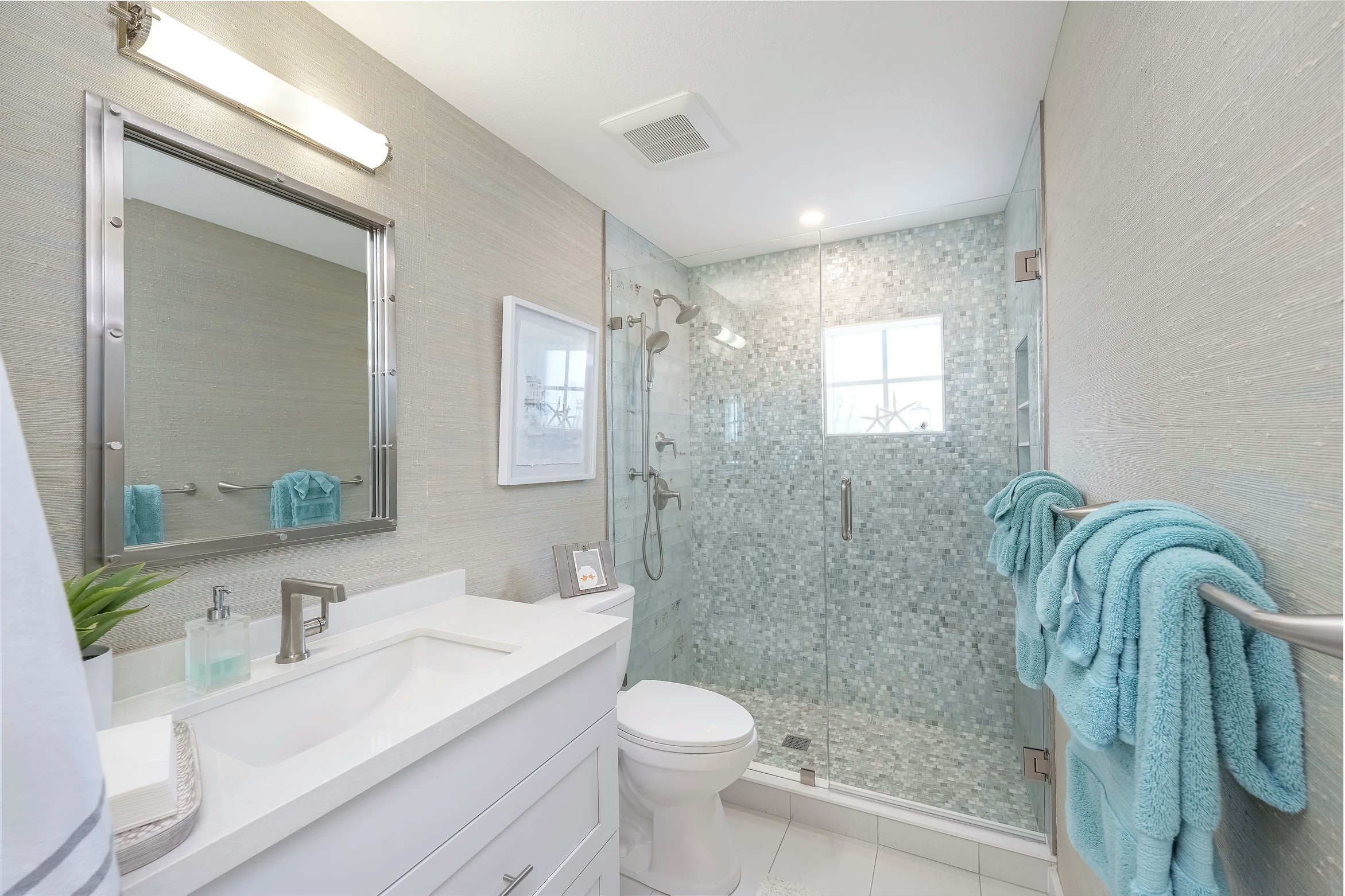 Modern bathroom renovation with marble tiles and blue accents at Sunset Marina