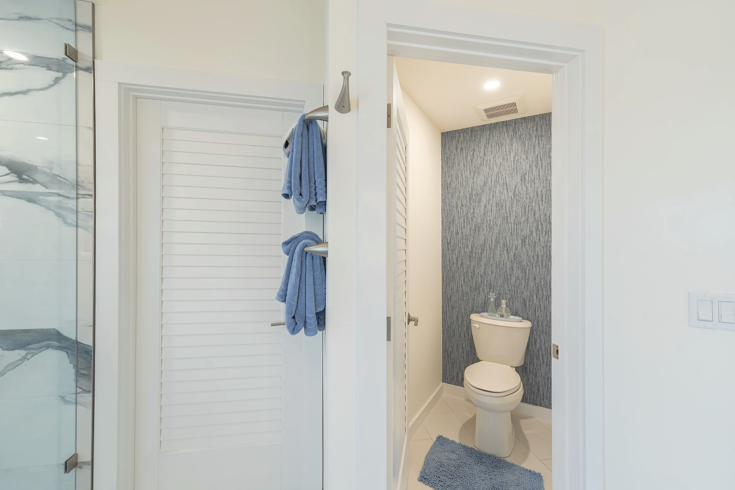 Contemporary bathroom with blue-gray tiled shower and glass partition in Sunset Marina condo