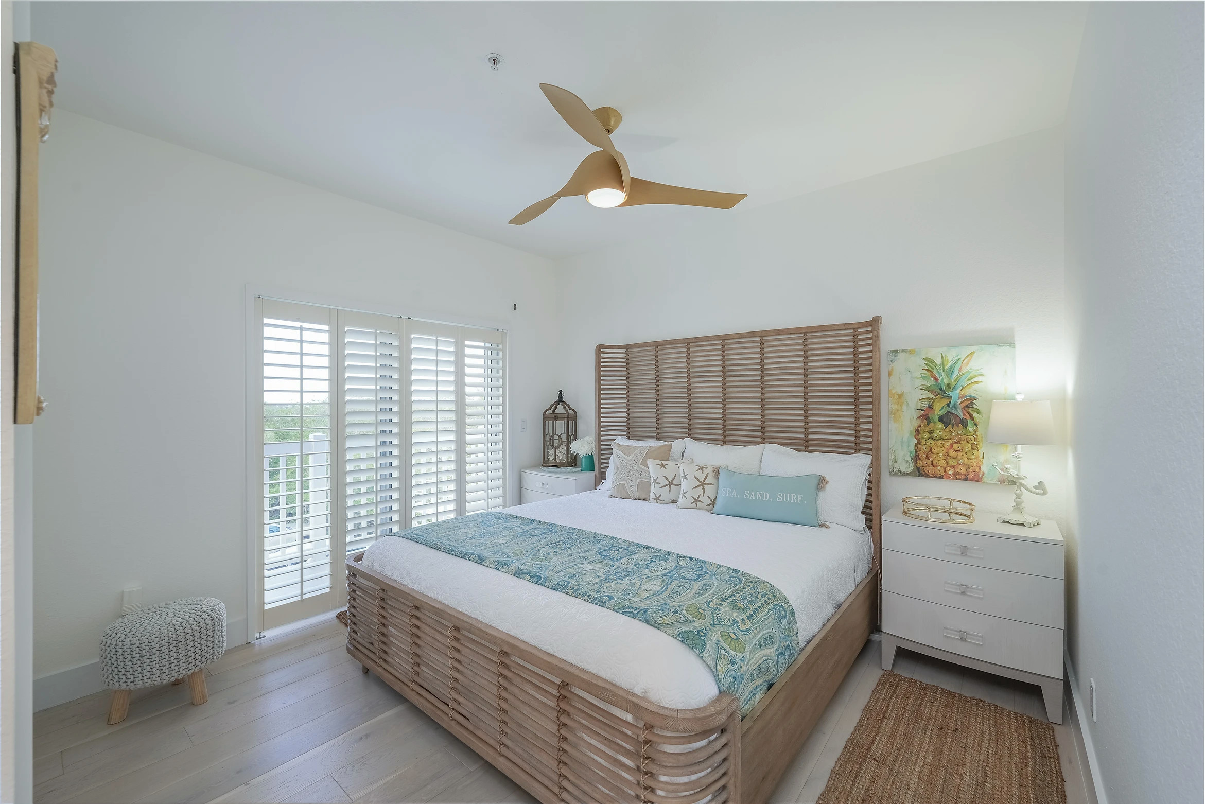 Bright coastal-themed bedroom with wooden furniture and natural light at Sunset Marina