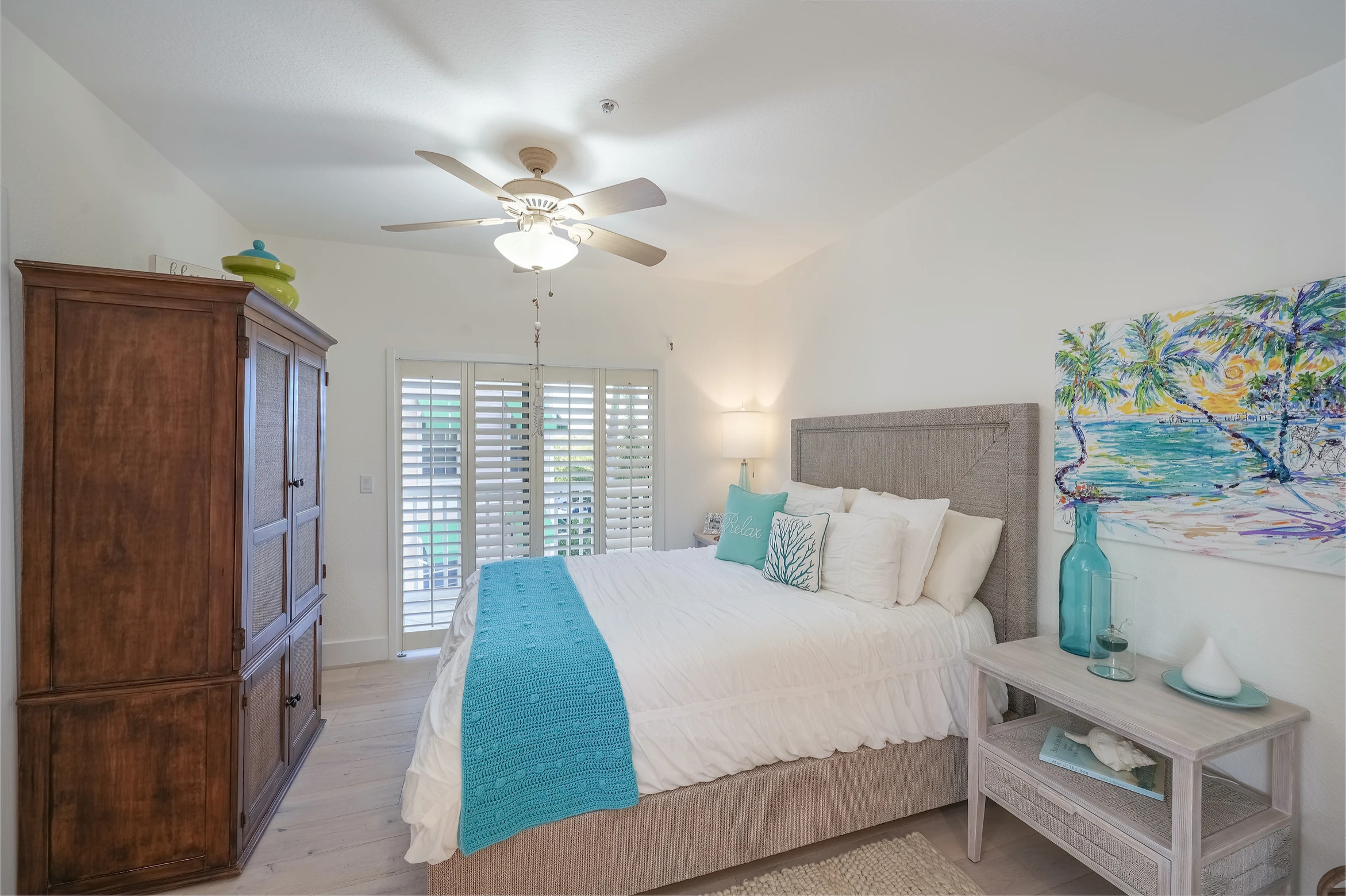 Modern bedroom with blue and white bedding and natural wood furniture at Sunset Marina