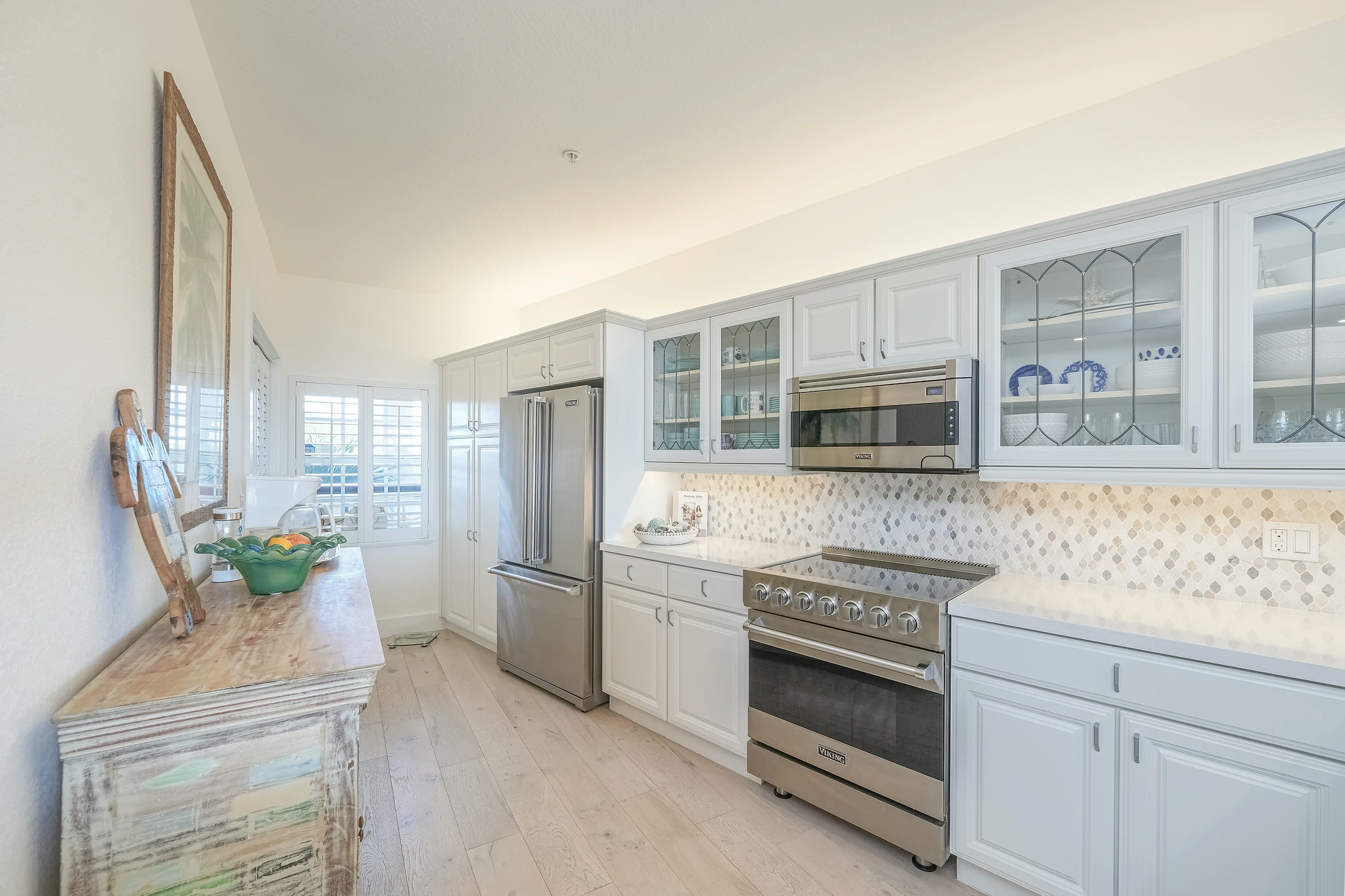 Modern kitchen with white cabinets and blue backsplash in Sunset Marina condo